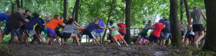 Image of campers playing tug of war in the mud pit