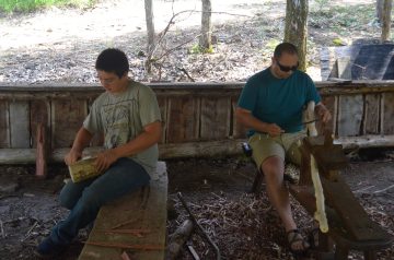 Image of a camper and staff woodworking